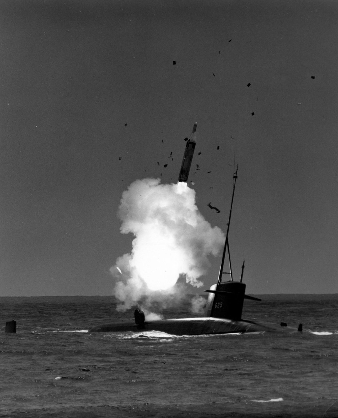 Black-and-white photograph of a Polaris A-2 missile rising out of a cloud of smoke as it launches from the surfaced submarine USS Henry Clay off Cape Kennedy, 1964.